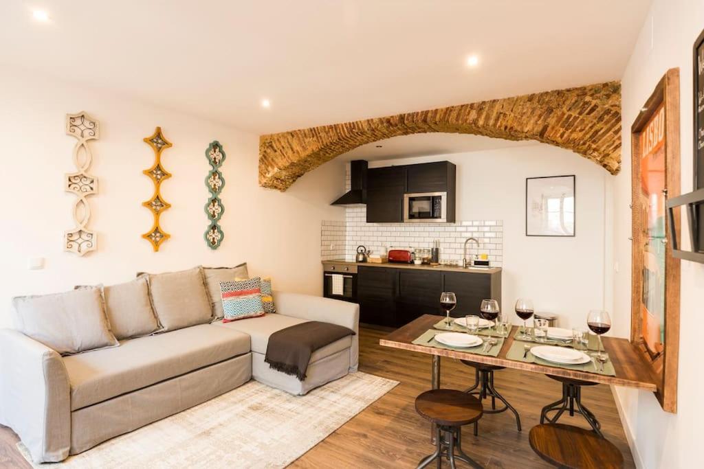ein Wohnzimmer mit einem Sofa und einem Tisch in der Unterkunft Ola Lisbon - Castelo III in Lissabon