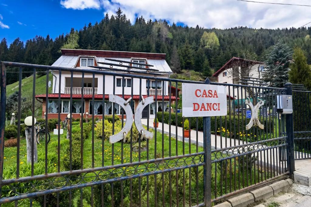 a gate with a sign in front of a house at Casa Danci II in Borşa