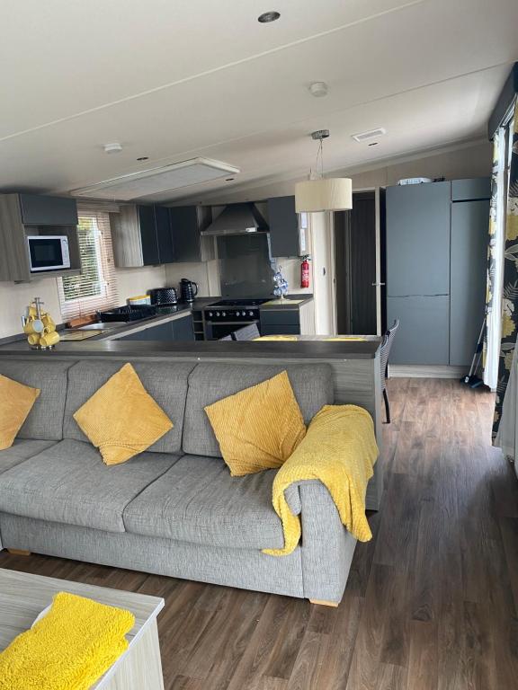 a living room with a gray couch with yellow pillows at Aurvegene in Weeton