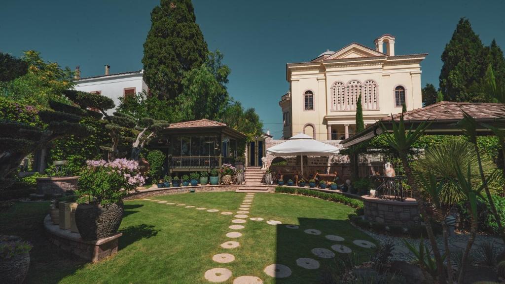 einen Garten vor einem großen weißen Gebäude in der Unterkunft Nisi Hotel in Ayvalık