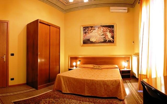 a bedroom with a bed and a painting on the wall at La Luna Guest House in Florence