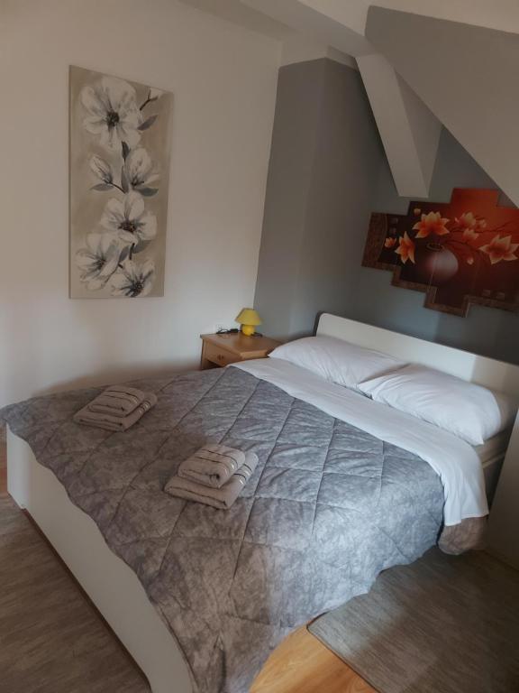 1 dormitorio con 1 cama grande y toallas. en Guest House Neno, en Ogulin