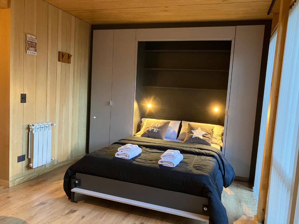 a bedroom with a bed with two towels on it at HUEPIL, Monoambiente Centrico in San Martín de los Andes