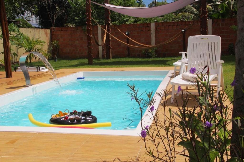 uma piscina com um barco de brinquedo e uma jangada em Chalé Ubá em Novo Airão