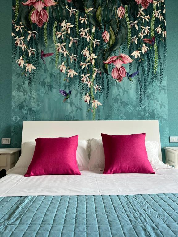 里米尼的住宿－Vespucci Home，一间卧室配有带粉红色枕头的床和花卉壁纸