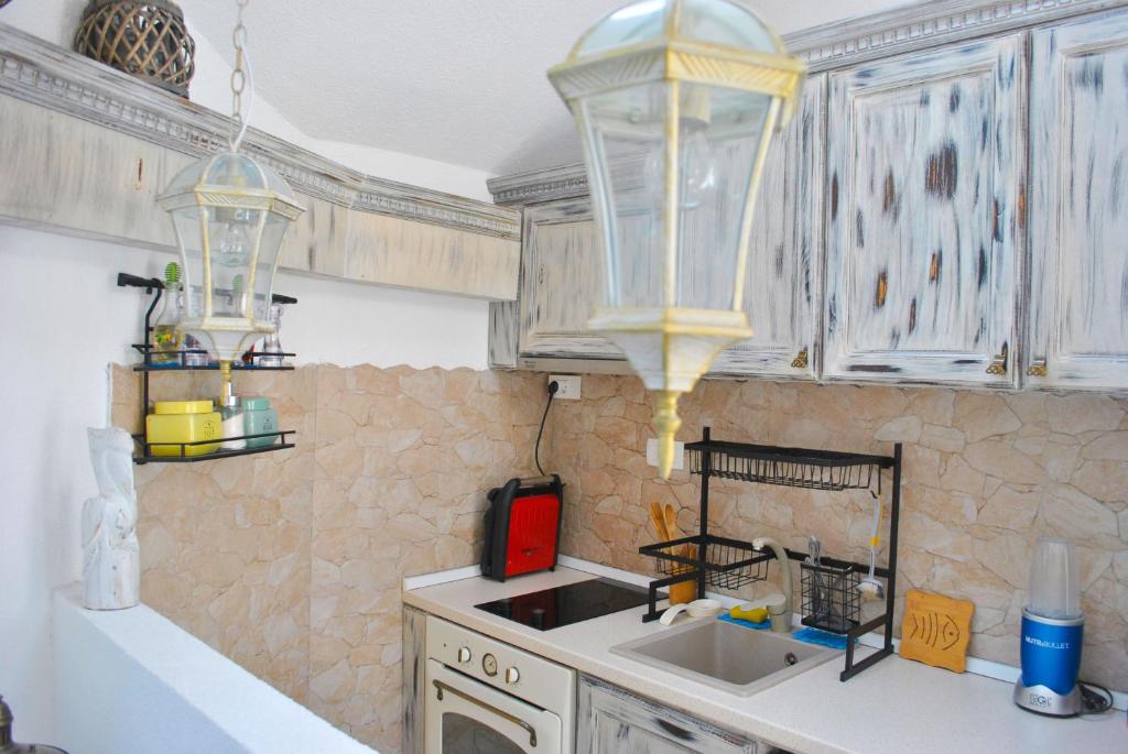 a kitchen with a sink and two chandeliers at Apartment Mediterraneo Blue Sky in Perast
