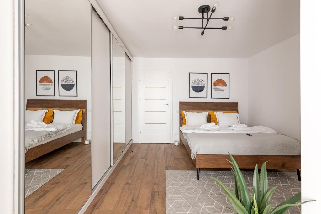 een slaapkamer met 2 bedden en een spiegel bij Moon Apartments in Cluj-Napoca