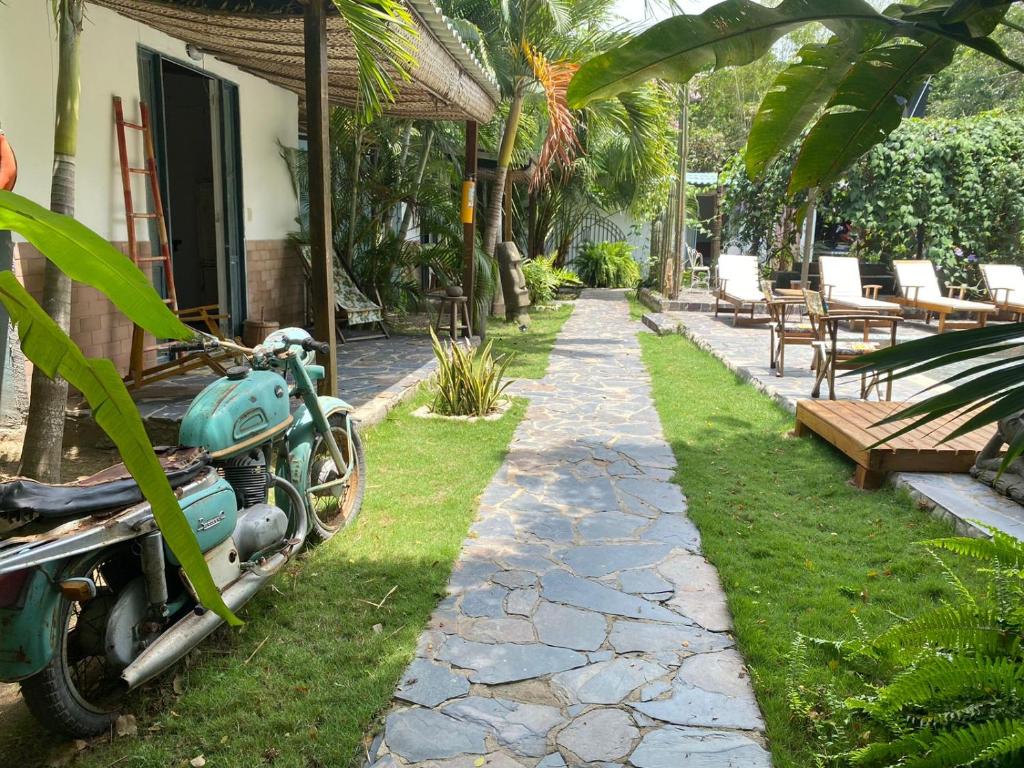 a motorcycle parked in front of a house with a path at Ekaa Hotel in Palomino