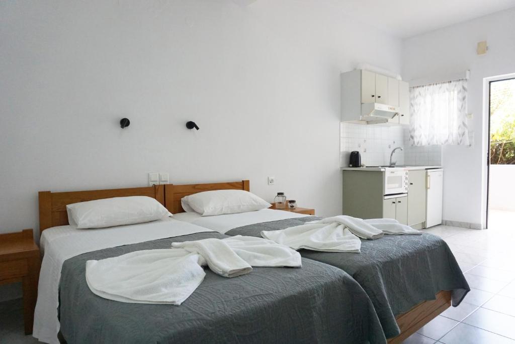 um quarto com 2 camas e toalhas brancas em Aphrodite Studios & Apartment em Balíon