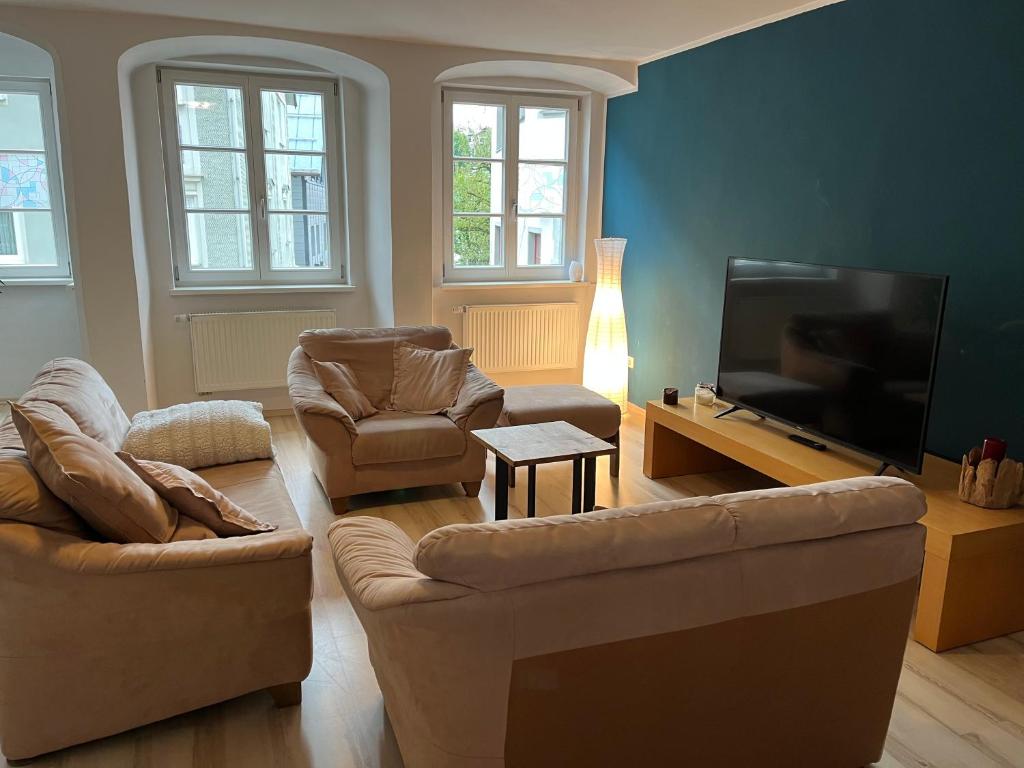 sala de estar con 2 sofás y TV de pantalla plana en Italienische Gastfreundlichkeit im Herzen von Immenstadt, en Immenstadt im Allgäu