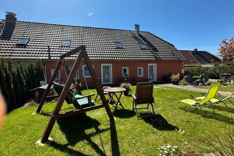 a yard with chairs and a table and a house at Bauernhaus am Plauer See mit Kamin in Zarchlin