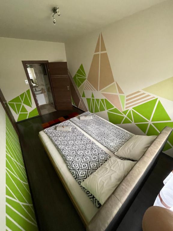 a bedroom with a bed with green and white walls at Exkluzív Apartman Debrecen in Debrecen