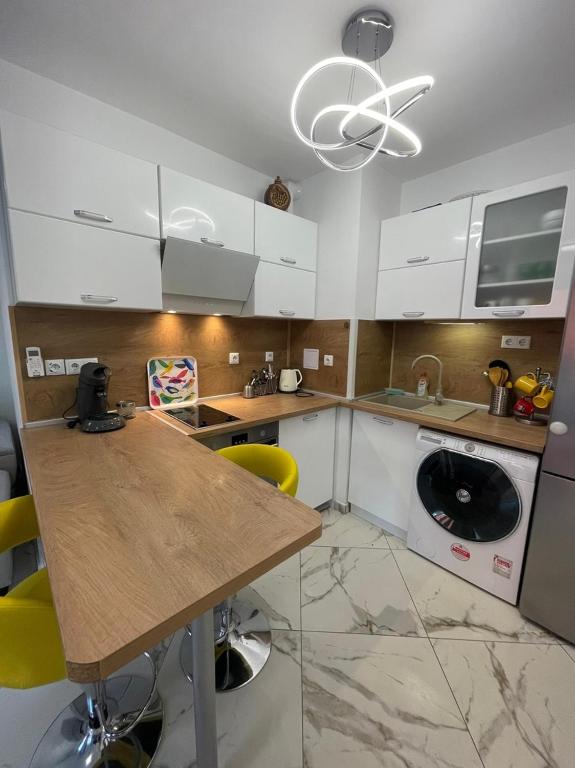 a kitchen with a wooden table and yellow chairs at Sun&Moon Apartment Obzor in Obzor