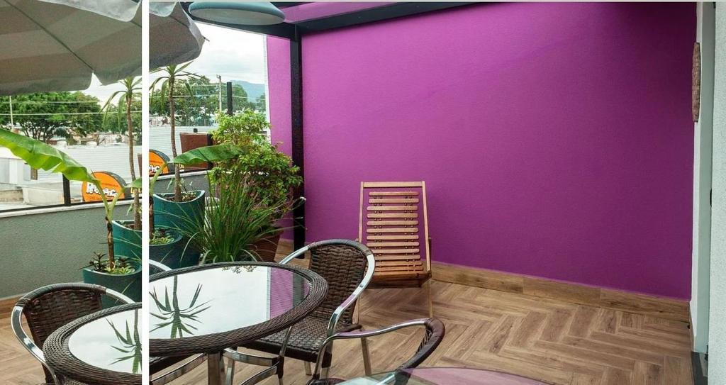 una mesa y sillas en un balcón con una pared púrpura en Apto aconchegante e familiar em BC, en Balneário Camboriú