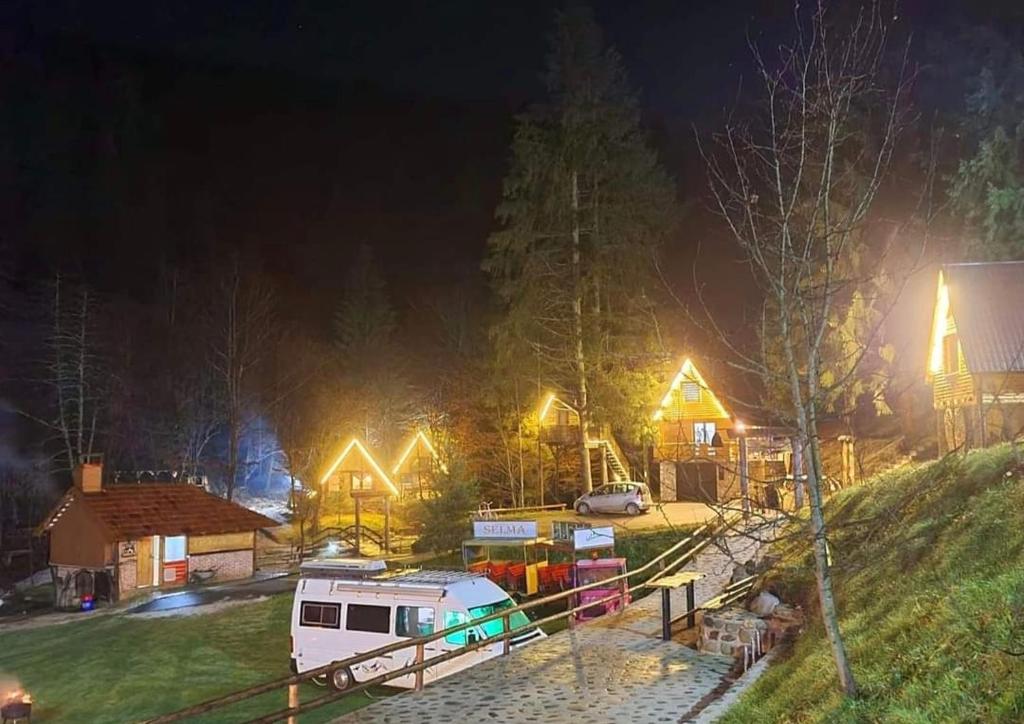 Una caravana estacionada en un patio por la noche en Etno selo BISTROVO, en Vitez