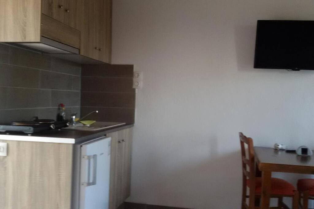 a kitchen with a counter and a table with a television at ΠΑΝΟΡΑΜΑ in Aigáni