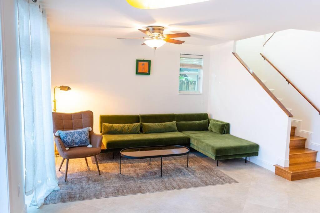 a living room with a green couch and a table at Coconut Grove Hidden Sanctuary Townhouse in Miami