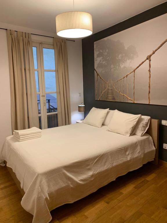 a bedroom with a large white bed with a bridge painting on the wall at Hermoso piso en el centro de Barcelona in Barcelona