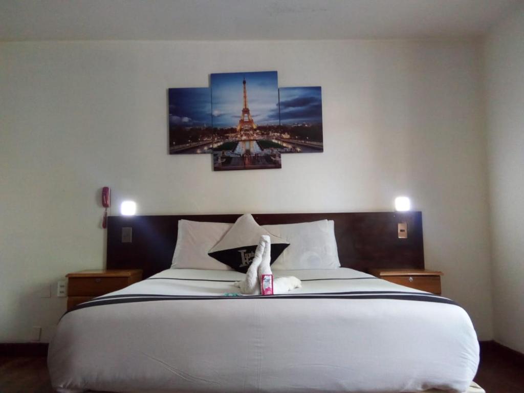 a bedroom with a bed with two pictures of the eiffel tower at Isabela Hotel in La Paz