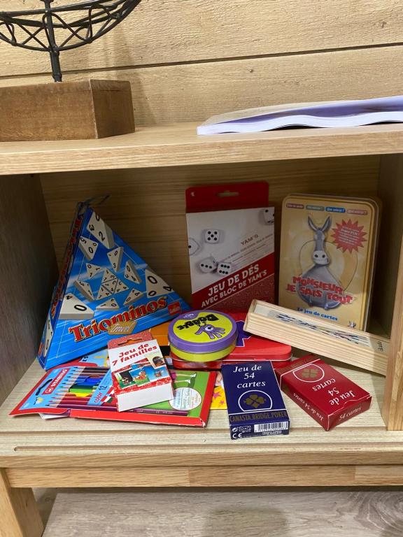 a shelf with books and other items on it at Le Nid du Cygne in Houlle