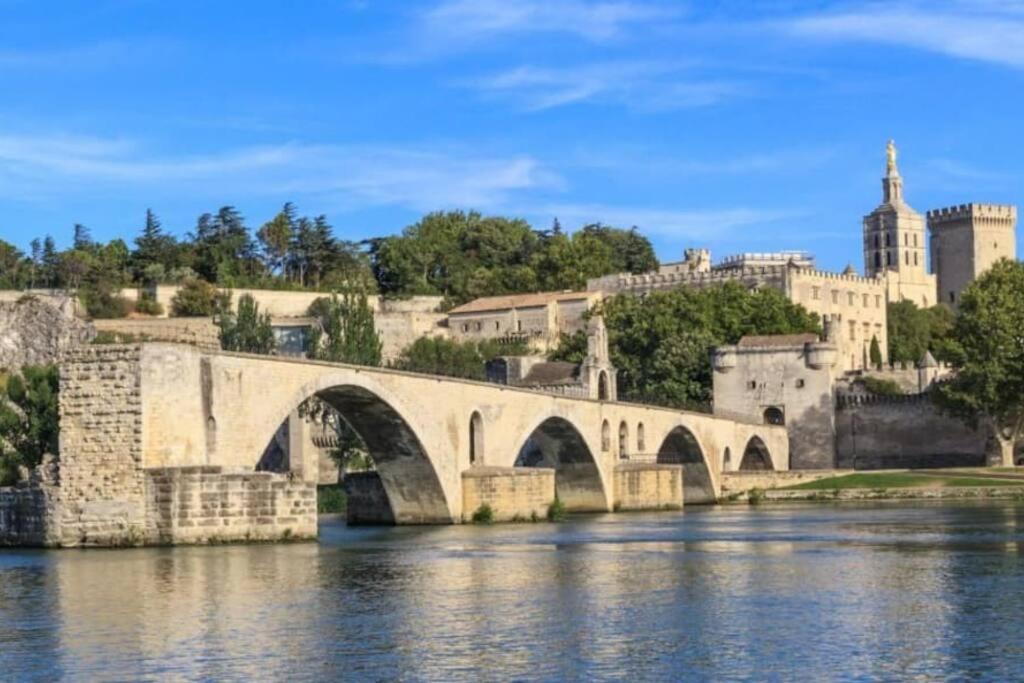a bridge over a river in front of a castle at La Cigale - Vieux Village - Charmante Maisonnette climatisée avec Jardin in Villeneuve-lès-Avignon