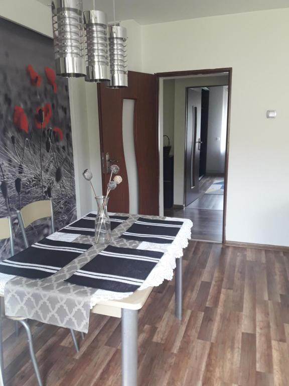 a dining room with a table with a glass top at Apartament u Dany Las wita Was w otoczeniu gór i dzikiej przyrody in Golińsk