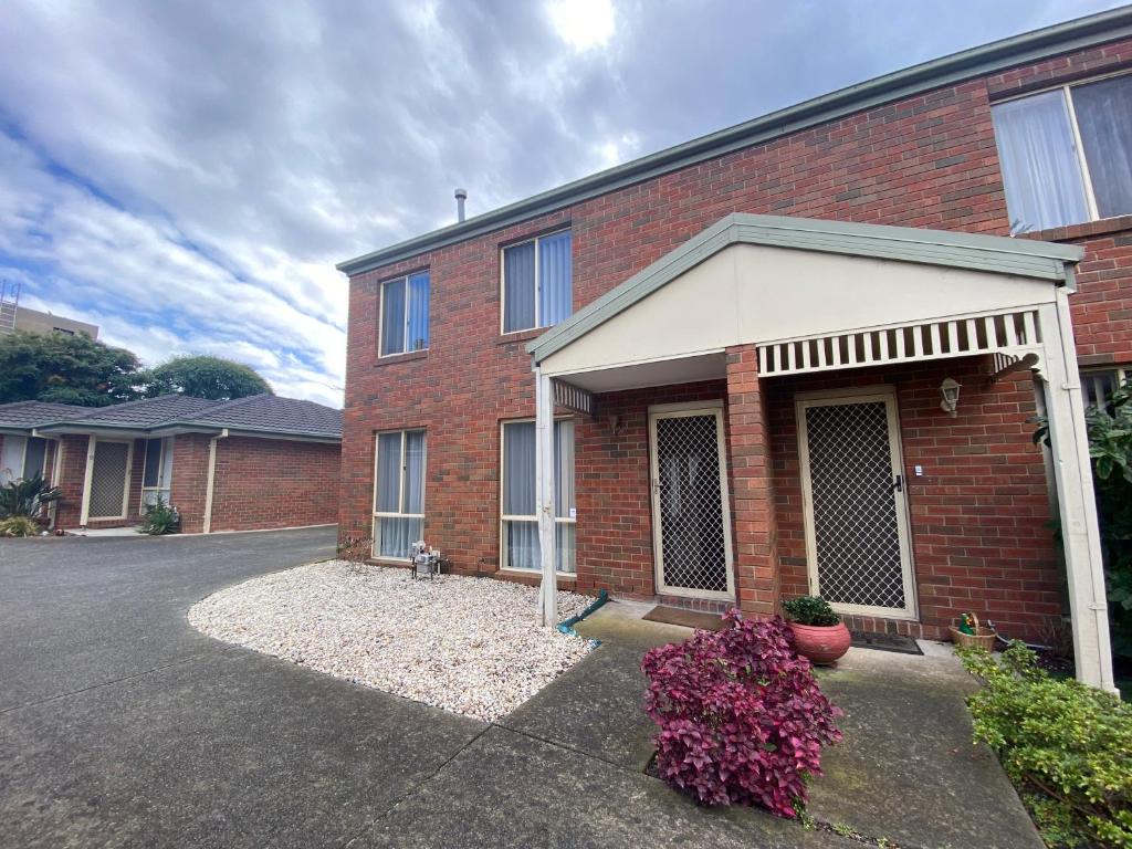 una casa in mattoni rossi con un garage bianco di 5 Beds-Whole House-Carrum Beach- Patterson Lake-Fully Furnished a Carrum
