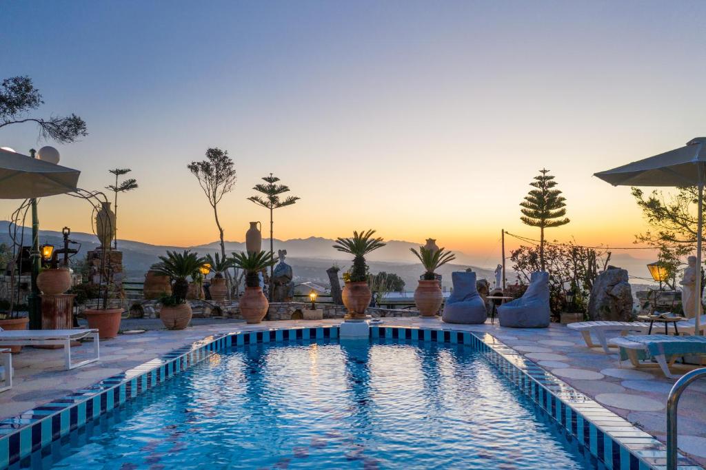 uma piscina com um pôr-do-sol ao fundo em Blue Panorama Villas em Giannoudi