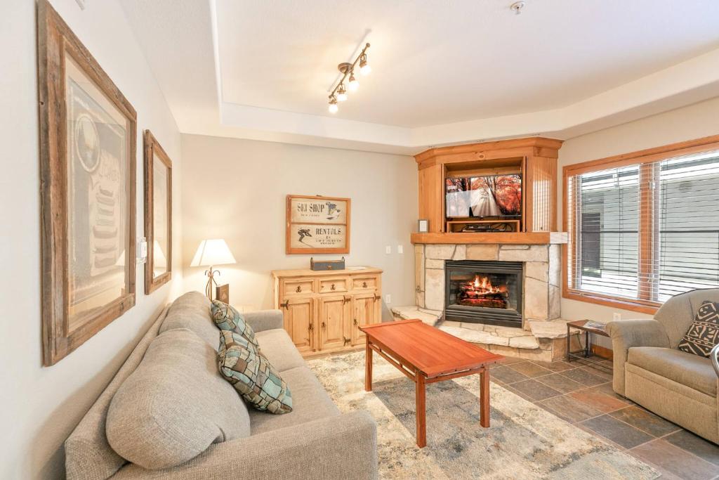 a living room with a couch and a fireplace at Riverbend Centennial Run Condo: Ski In/Out in Breckenridge