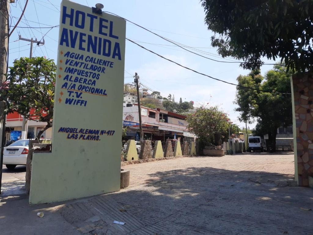 a sign for a hotel in a street at Hotel Avenida in Acapulco