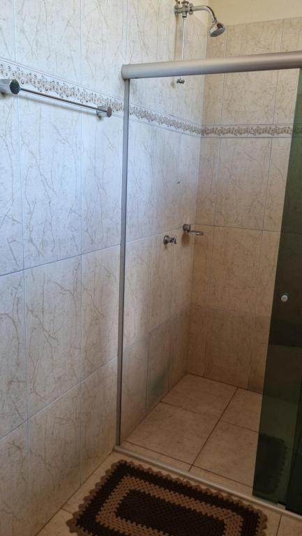 a shower with a glass door in a bathroom at Chalé da Serra in Cavalcante