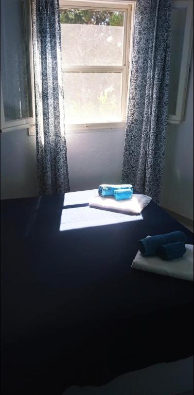 a bed with a window and two towels on it at Villa Vera trifamigliare con ingresso diretto 20 mt al mare clima wi-fi bbq in Cala Liberotto