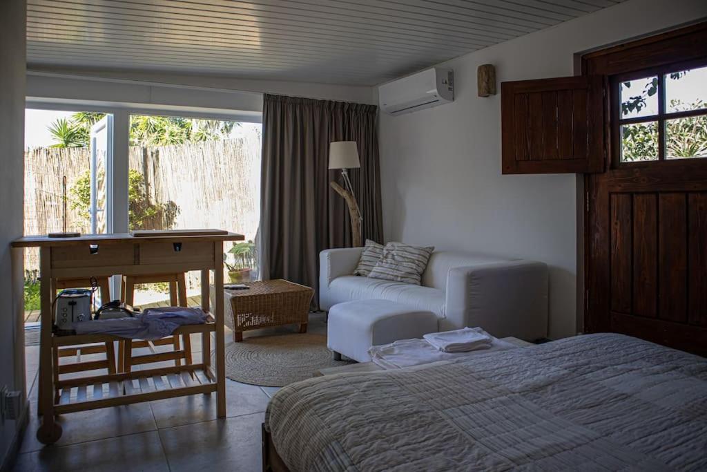 1 dormitorio con cama, sofá y mesa en Pé na Praia, en Torres Vedras