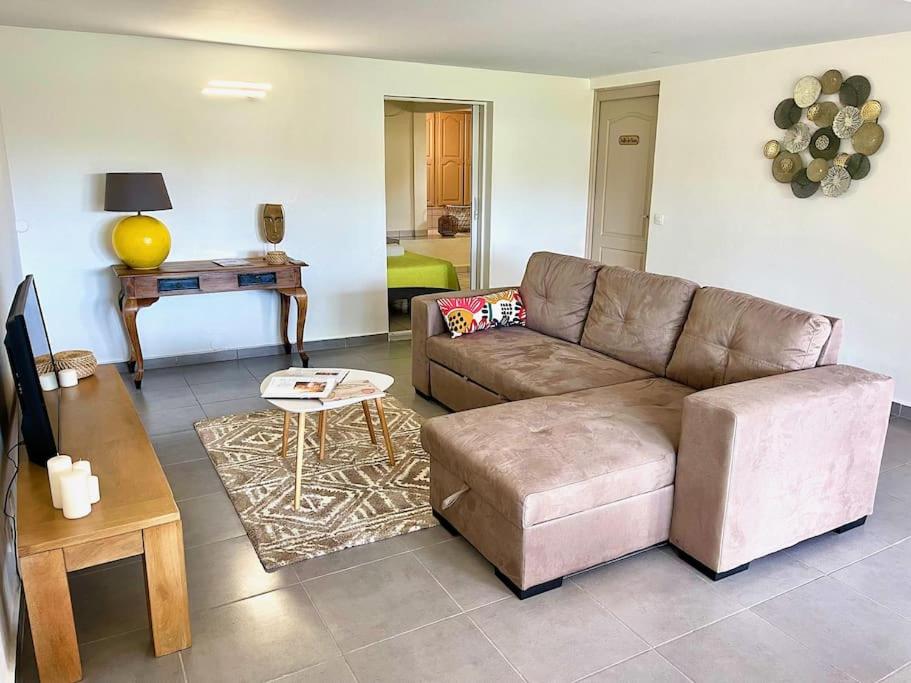 uma sala de estar com um sofá e uma mesa em Villa le Cotonnier Lodge em Saint-François