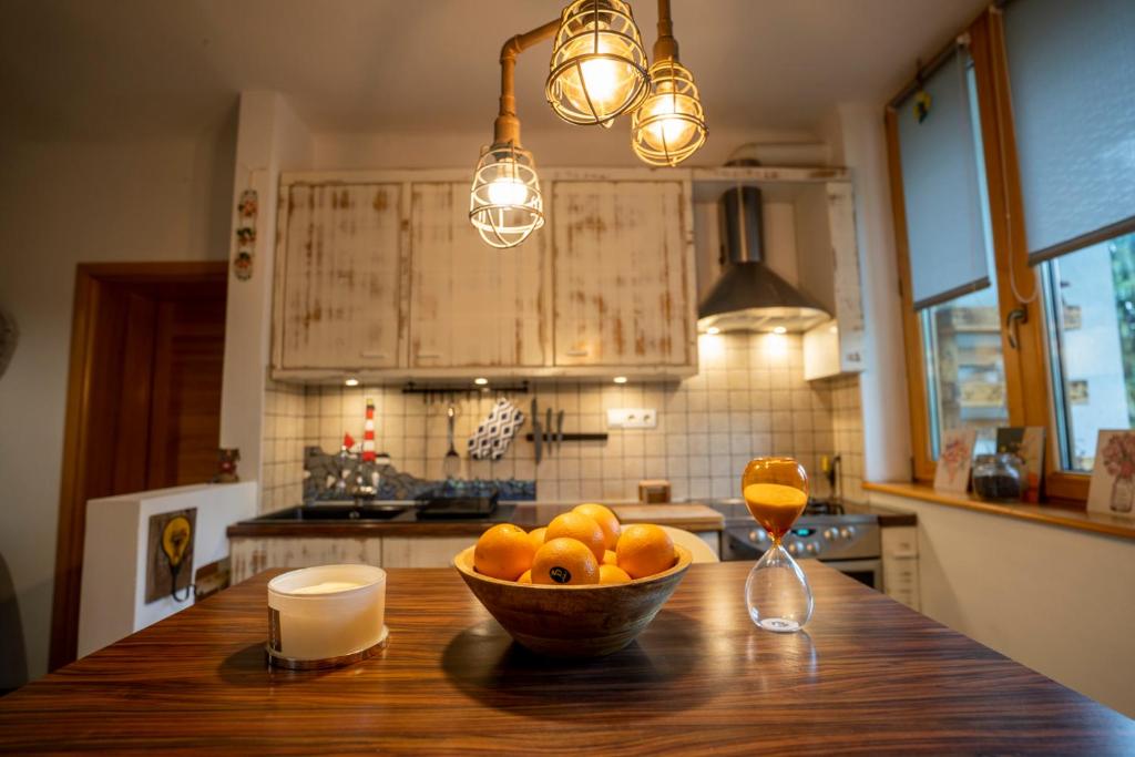 a bowl of fruit on a wooden table in a kitchen at Tri pera -- self check in in Osijek