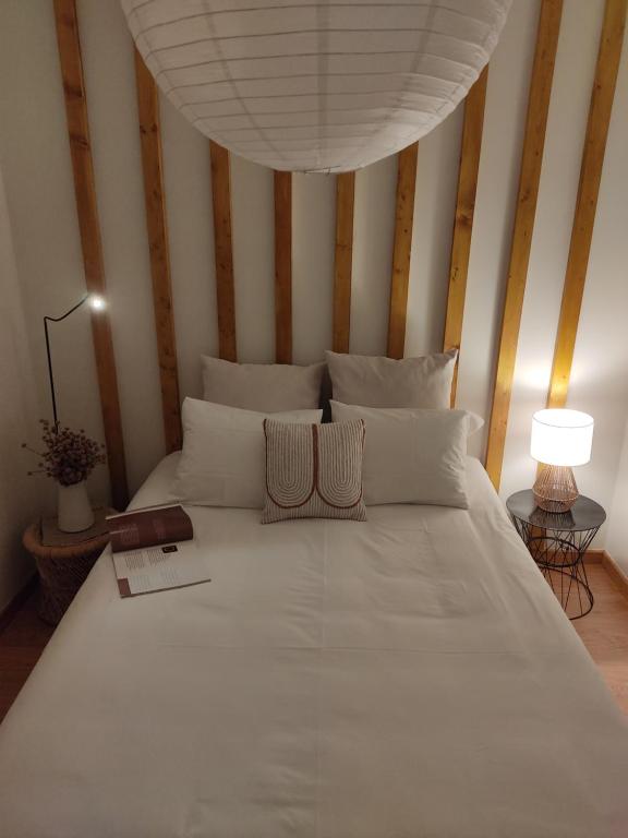 1 dormitorio con 1 cama blanca grande y paredes a rayas en Douro Valley Terrace Apartments, en Armamar