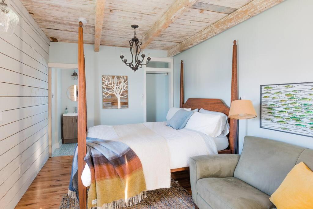 a bedroom with a bed and a couch and a chair at Seahorse Cottage in Indian Harbour