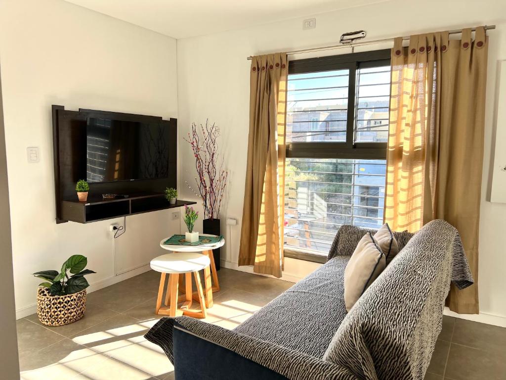 a living room with a blue couch and a window at Lumiere Apartments - Moderno Departamento en Complejo Residencial in Mendoza
