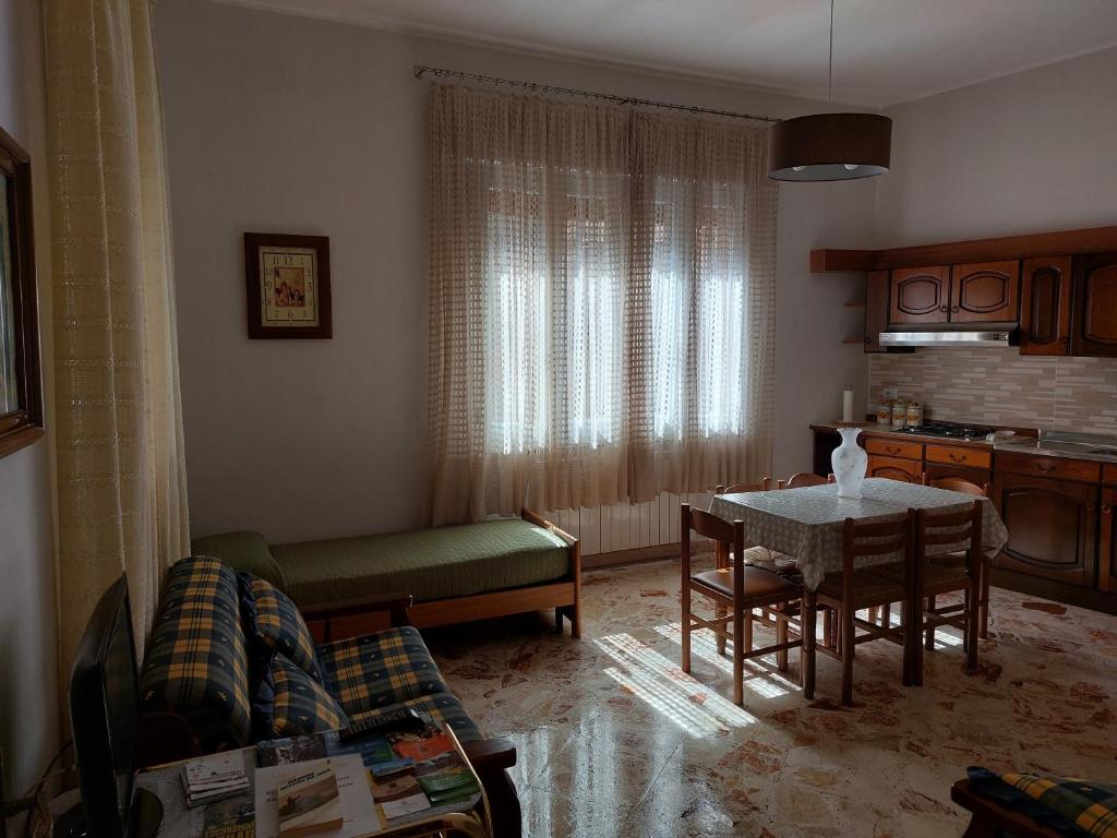 sala de estar con mesa y cocina en CASA VACANZE LINA, en San Mauro Castelverde