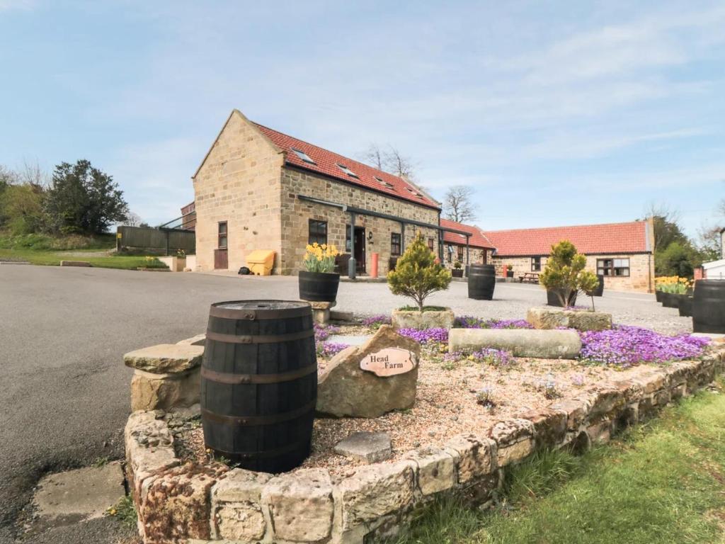 a brick building with a flower garden in front of it at The Granary - Uk43951 in Boosbeck