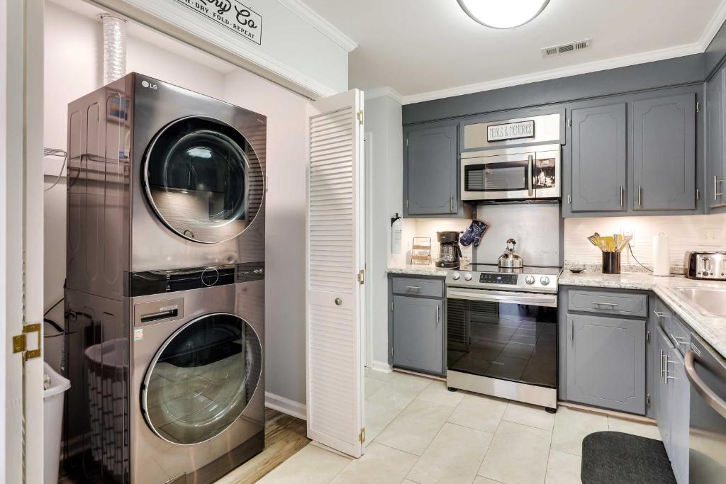 - une cuisine avec des placards gris et un lave-linge/sèche-linge dans l'établissement North Charleston Vacation Rental Near Cooper River, à Charleston