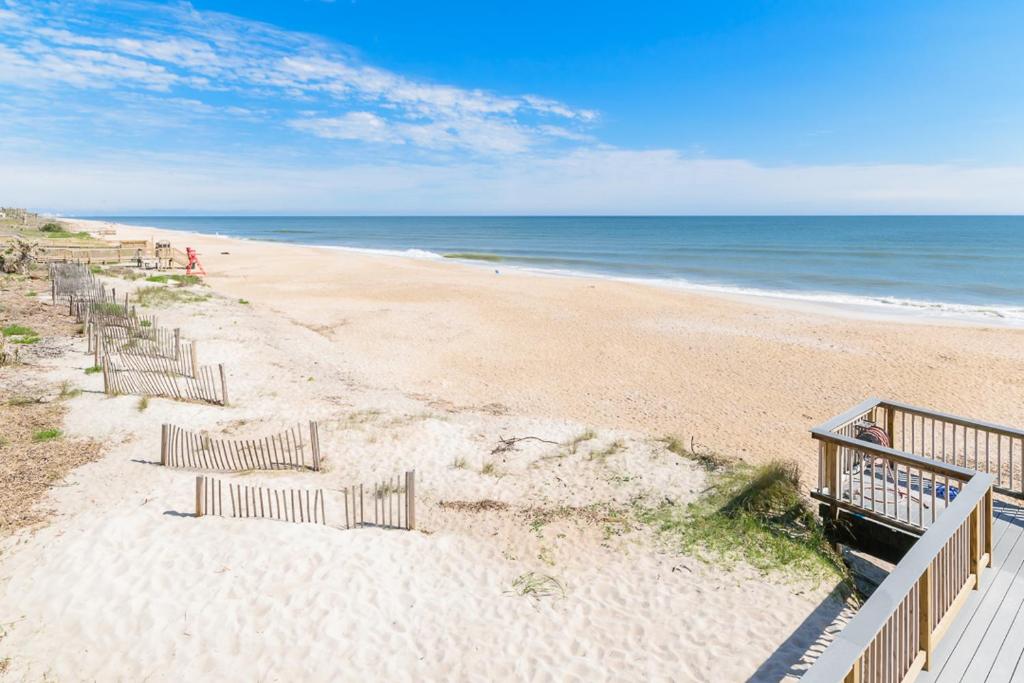 a sandy beach with stairs leading to the ocean at Ground Floor Convenient Gated Condo At Beach Sawgrass - Pet Friendly!!! in Ponte Vedra Beach