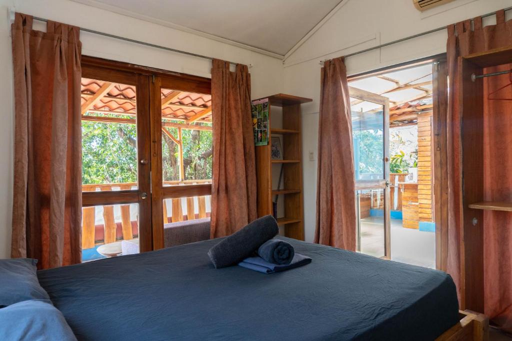 een slaapkamer met een bed en een groot raam bij 1 Bedroom G-Land Burnt Toast Surfcamp in Nosara