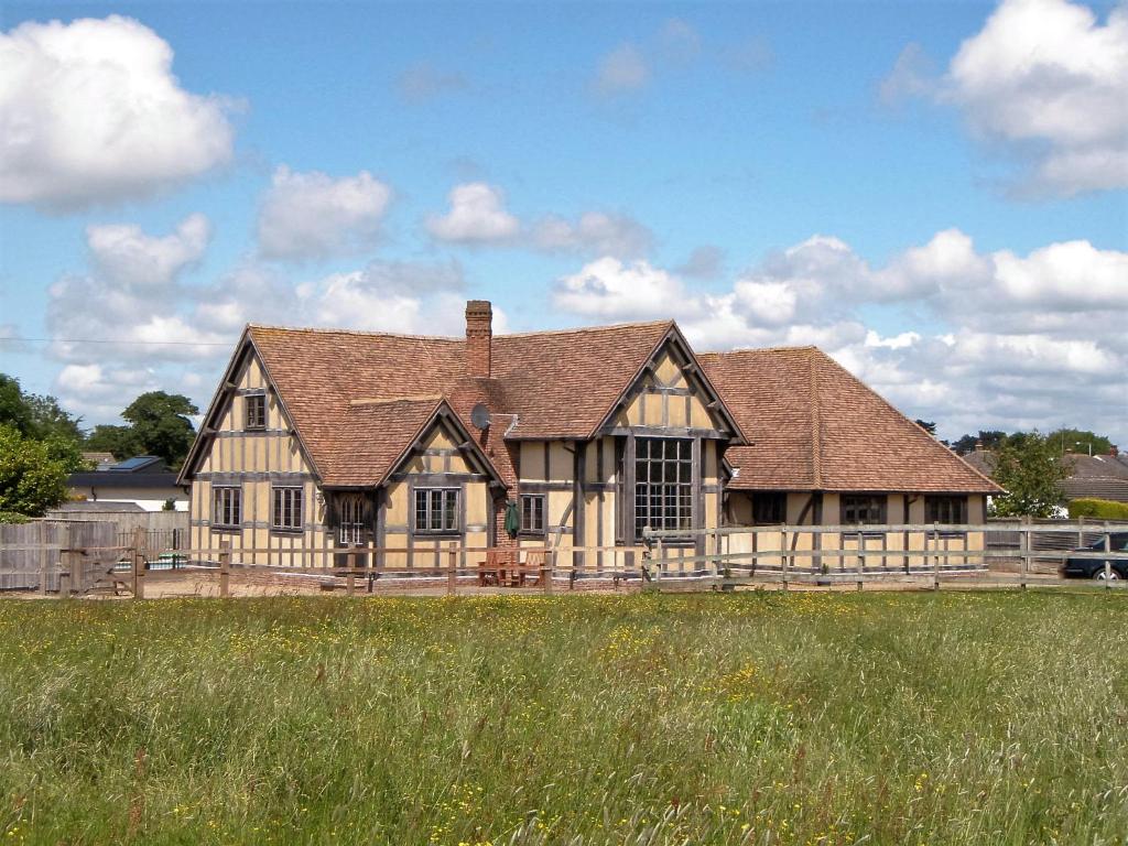 a large wooden house with a field in front of it at Fletchers Hall in Freckleton