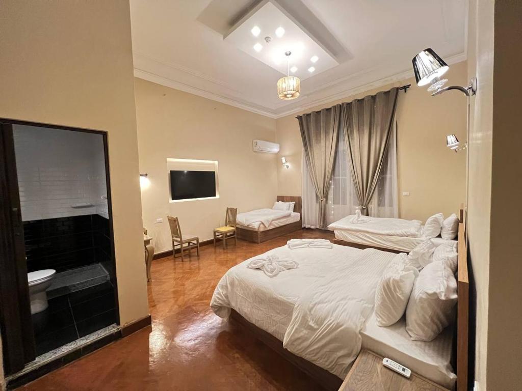 a hotel room with two beds and a television at Paris east in Cairo