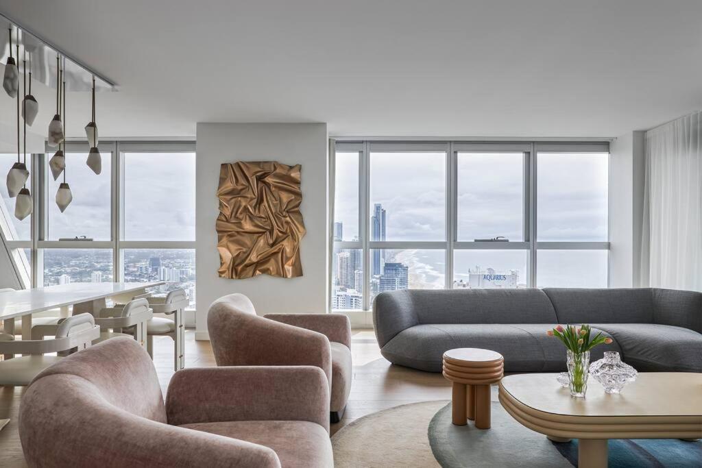 uma sala de estar com um sofá, cadeiras e uma mesa em The Jewel, A designer Condo in the Sky em Gold Coast