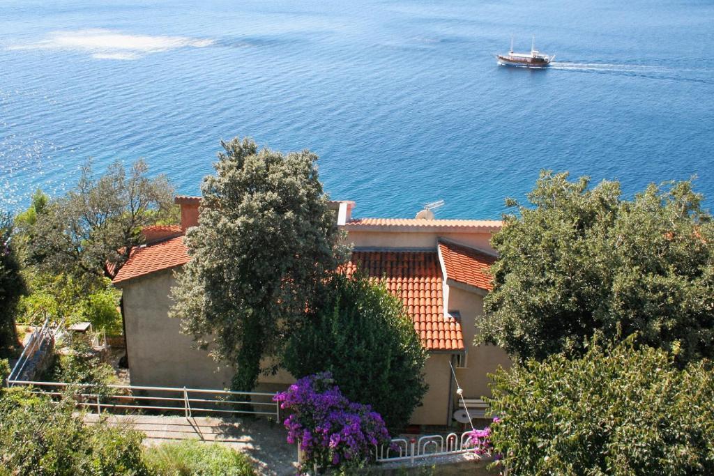 a house with a boat in the water at Apartments by the sea Stanici, Omis - 1028 in Tice