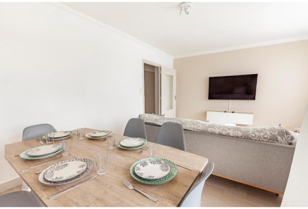 comedor con mesa de madera y sillas en Appartement logement entiers en Rodez