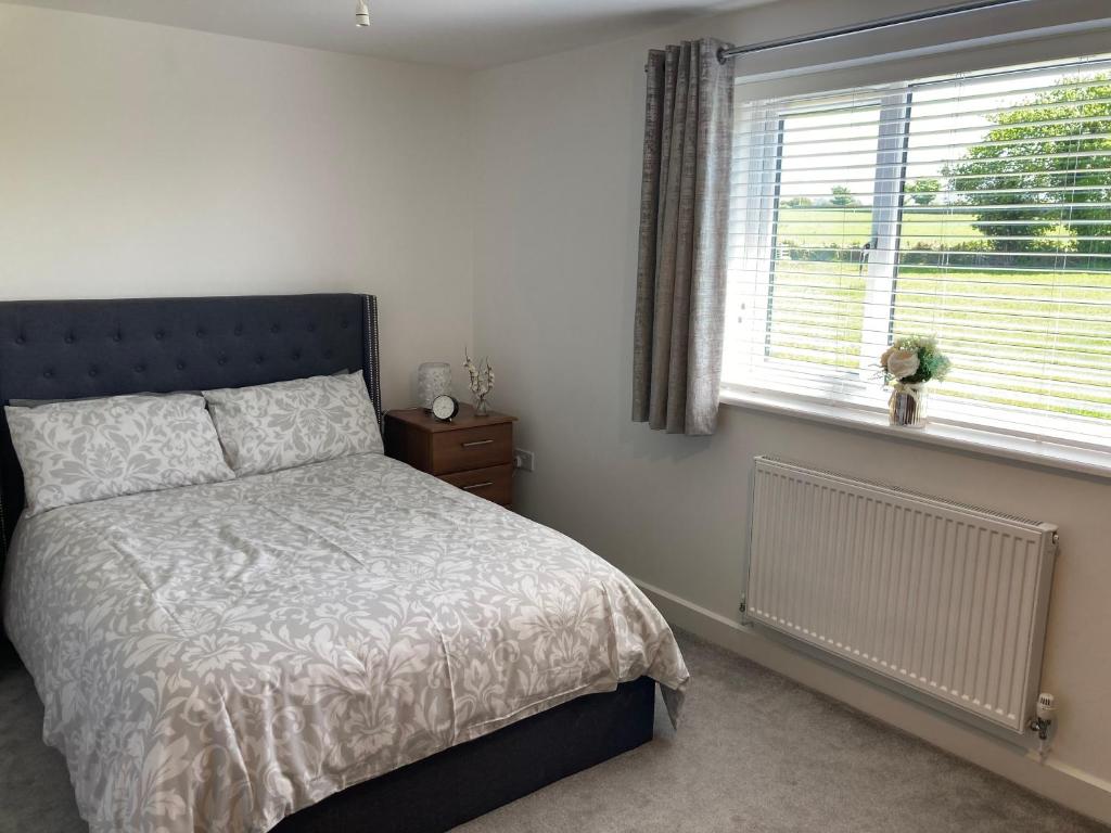 a bedroom with a bed and a window at Cozy & Spacious home In the heart of Snowdonia in Llanddeiniolen