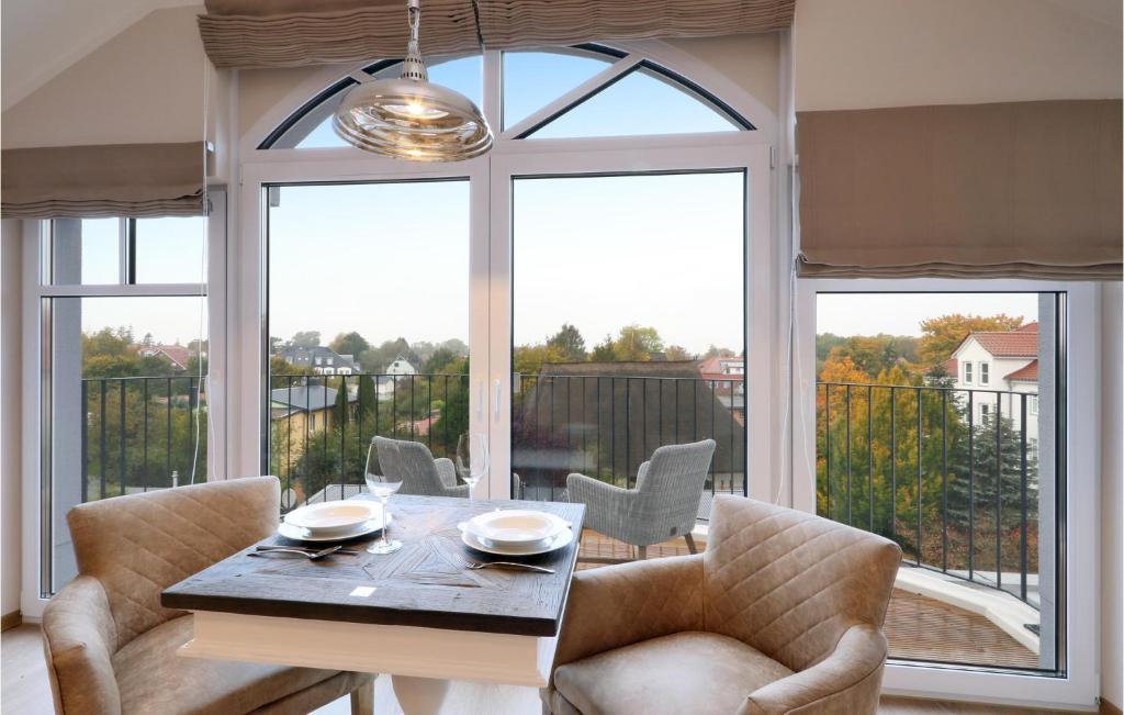 ein Esszimmer mit einem Tisch und Stühlen sowie einem großen Fenster in der Unterkunft Baltischer Hof Apartment 67 in Boltenhagen